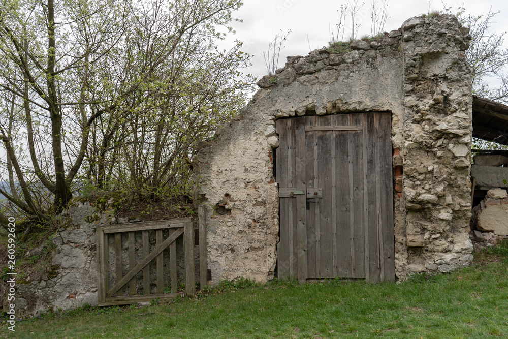 Alte Holztüre in einer verfallenen Holzmauer Alte Holztüre in einer verfallenen Holzmauer