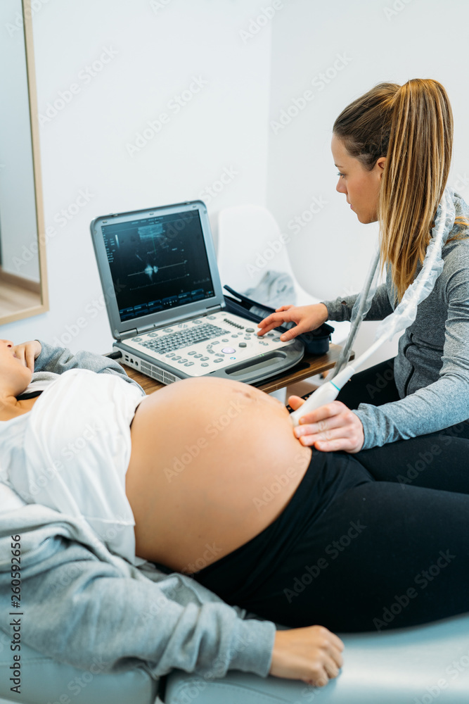 Doctor performing an ultrasound scan on pregnant woman Doctor performing an ultrasound scan on pregnant woman