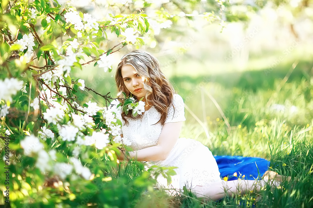 girl sniffing flowers / fresh spring flowers of apple, portrait of a girl in a beautiful spring garden girl sniffing flowers / fresh spring flowers of apple, portrait of a girl in a beautiful spring garden
