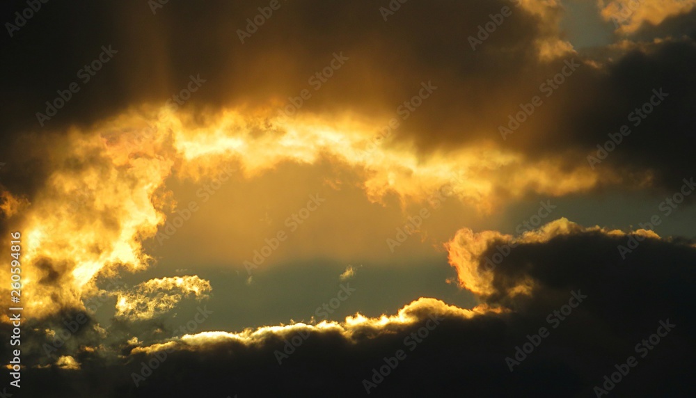 Beautiful golden sunset on black dramatic clouds background