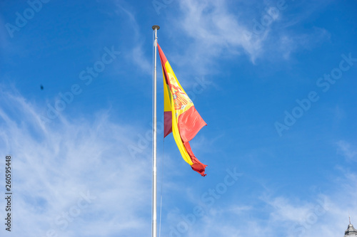 spain flag on a mast in the wind on blue sky background