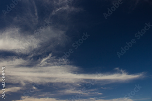 dark evening blue sky natural background with white clouds 