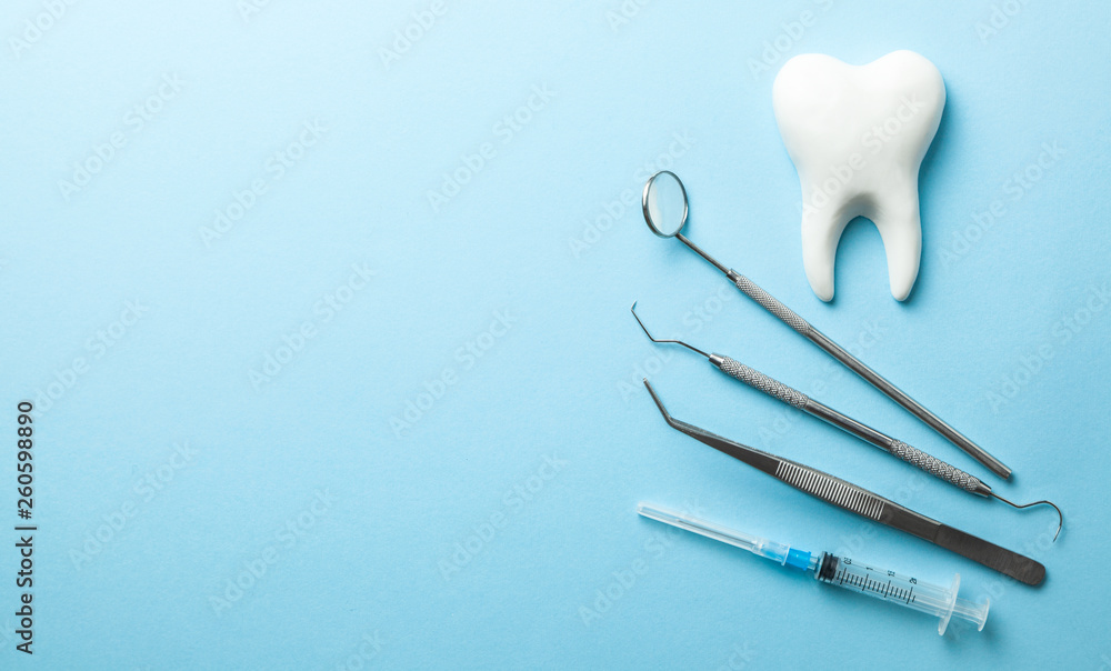 Foto de Tooth and dental instruments on blue background. Dental