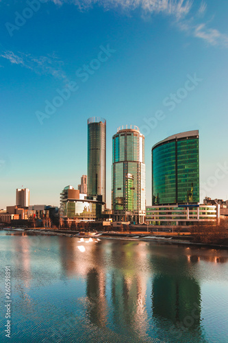 Evening cityscape of Yekaterinburg business city center reflecting in city pond