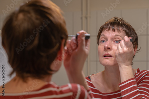 Paris, France - 03 23 2019: Woman doing makeup at home