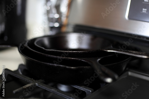 Cast iron skillets on a modern gas stove oven in a home.