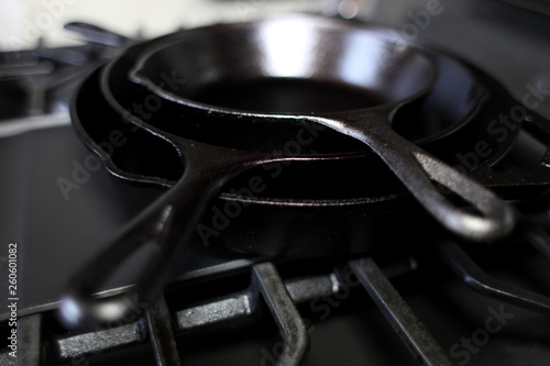 Cast iron skillets on a modern gas stove oven in a home. © Peter Kim