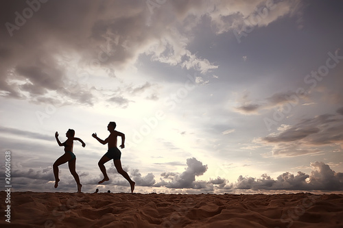 silhouettes of athletes running along the beach   sports summer in the warm sea  healthy rest  sports activity  summer vacation