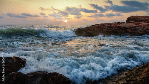 Shortly after sunrise, the seething waves beat against the rocky coast and the beach © wewi-creative
