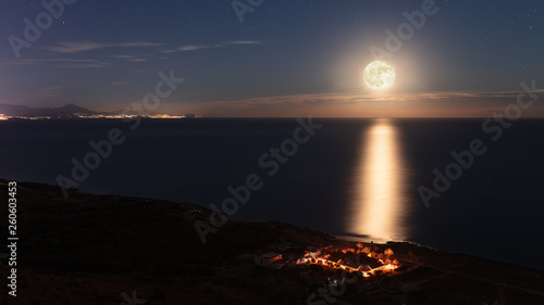 Принти на полотні A village on the coast is illuminated by the full moon and is brightly lit