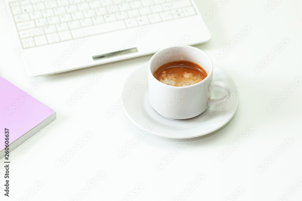 Coffee cup , laptop and lavender notpad on white table. Selective focus. Coffee cup , laptop and lavender notpad on white table. Selective focus.