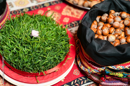 Semeni with a white rose in the middle and a bag of nuts on a tablecloth with national patterns and prints .