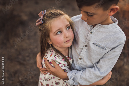 Close up portrait of young girl looking at brother in California field