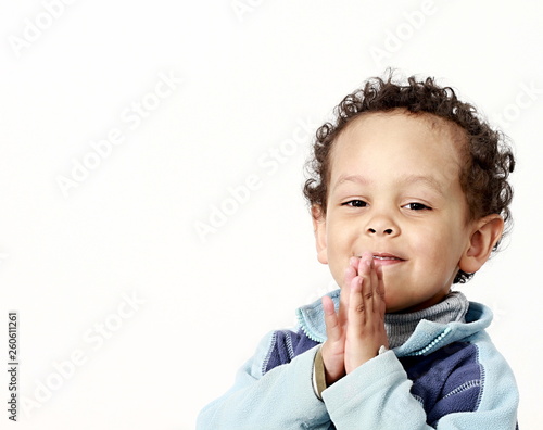 boy praying to God with hands held together stock photo