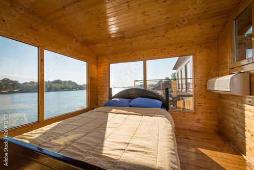 Beautiful view on river througw window of bedrom in wooden log cabin photo