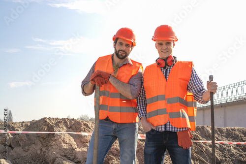 male workers engineers in helmets with the head, work, in the hands of a shovel