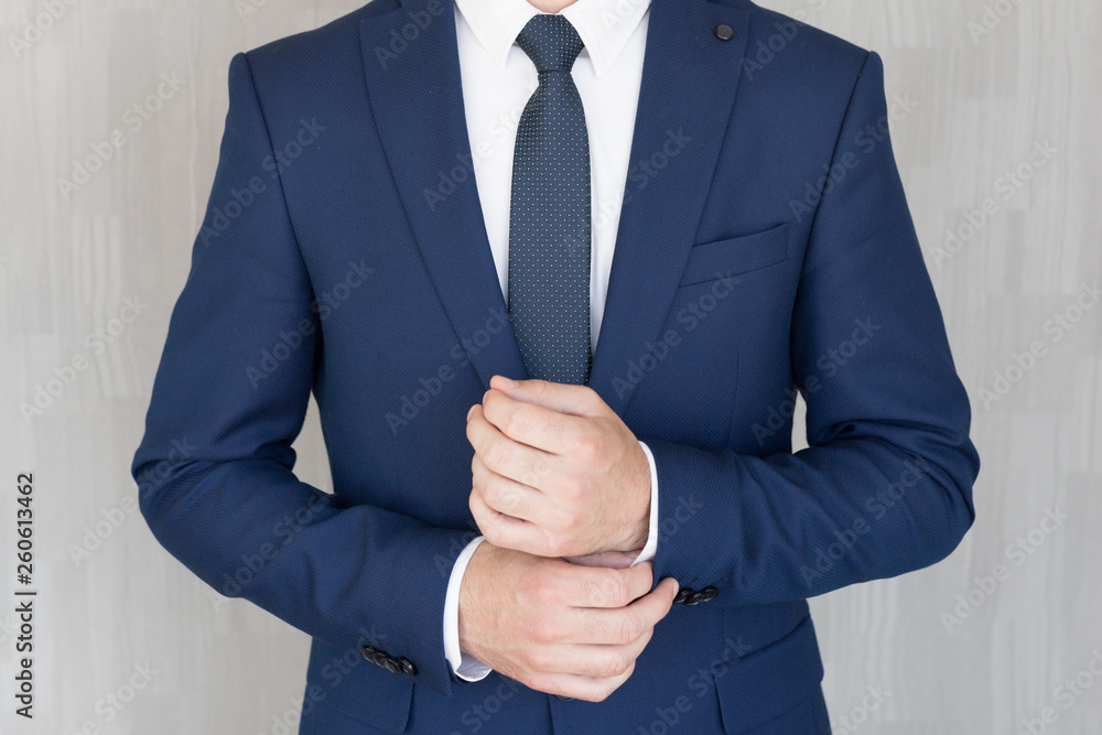 Naklejka Torso of anonymous businessman wearing beautiful fashionable classic navy blue suit against grey backgound