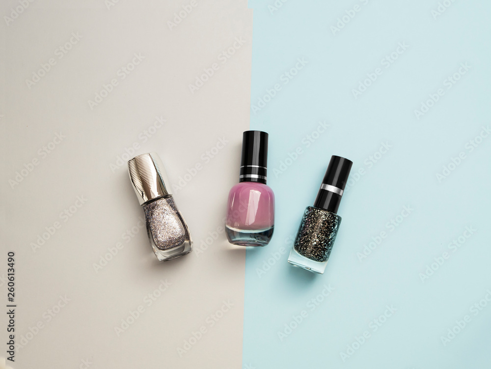 Beauty and care concept. Nail polish bottles different colors. Nail polish blue background. Manicure salon. Durability and quality of nail polish coating. Gel polish modern technology. Fashion trend Beauty and care concept. Nail polish bottles different colors. Nail polish blue background. Manicure salon. Durability and quality of nail polish coating. Gel polish modern technology. Fashion trend