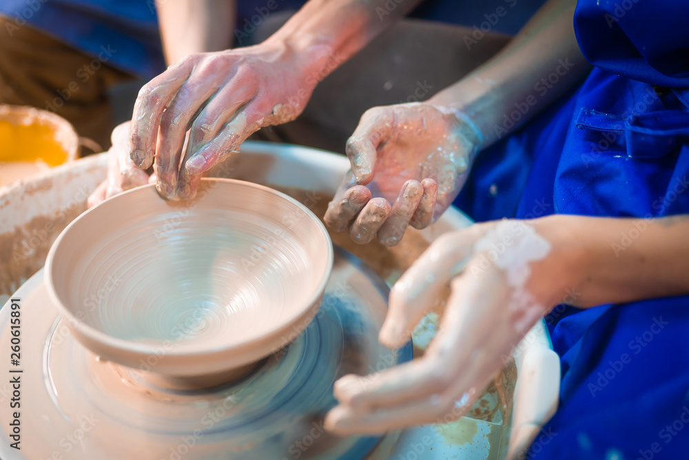 Traditional pottery making, man teacher shows the basics of pottery in art studio. Artist
