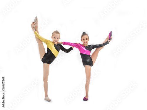 Two gymnastic girls with leg up isolated on white