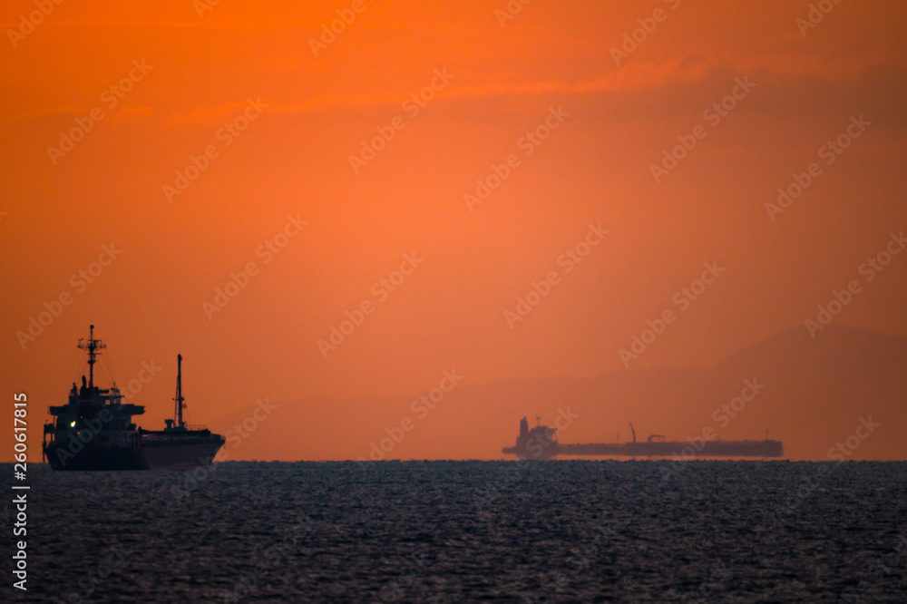朝焼けの水平線と船の影