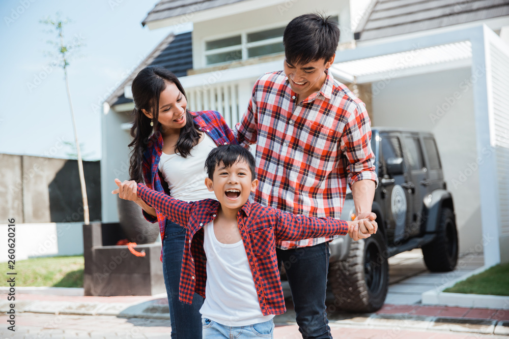 Φωτογραφία young asian family with kid in front of their house and car