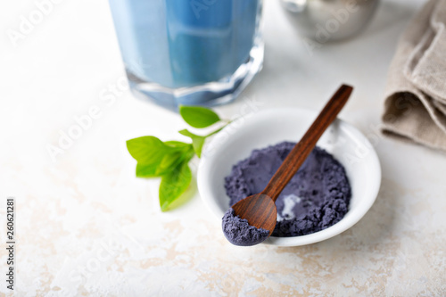 Photography Blue matcha tea powder and latte in tall glass, tea from the dried flowers of th