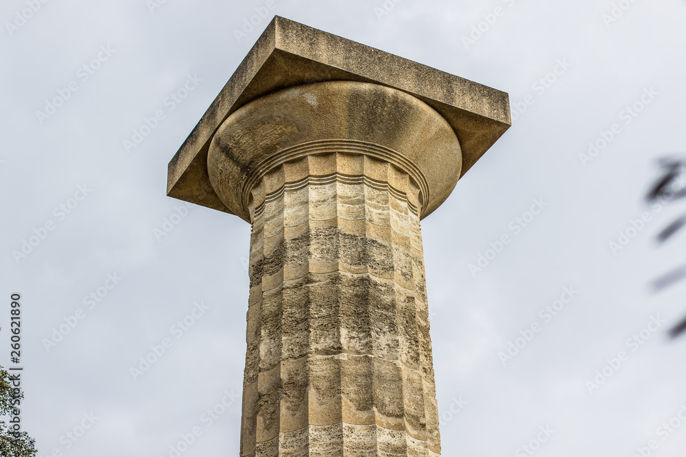 single high lonely stone antique column ancient Greece architecture object on gray cloudy sky background