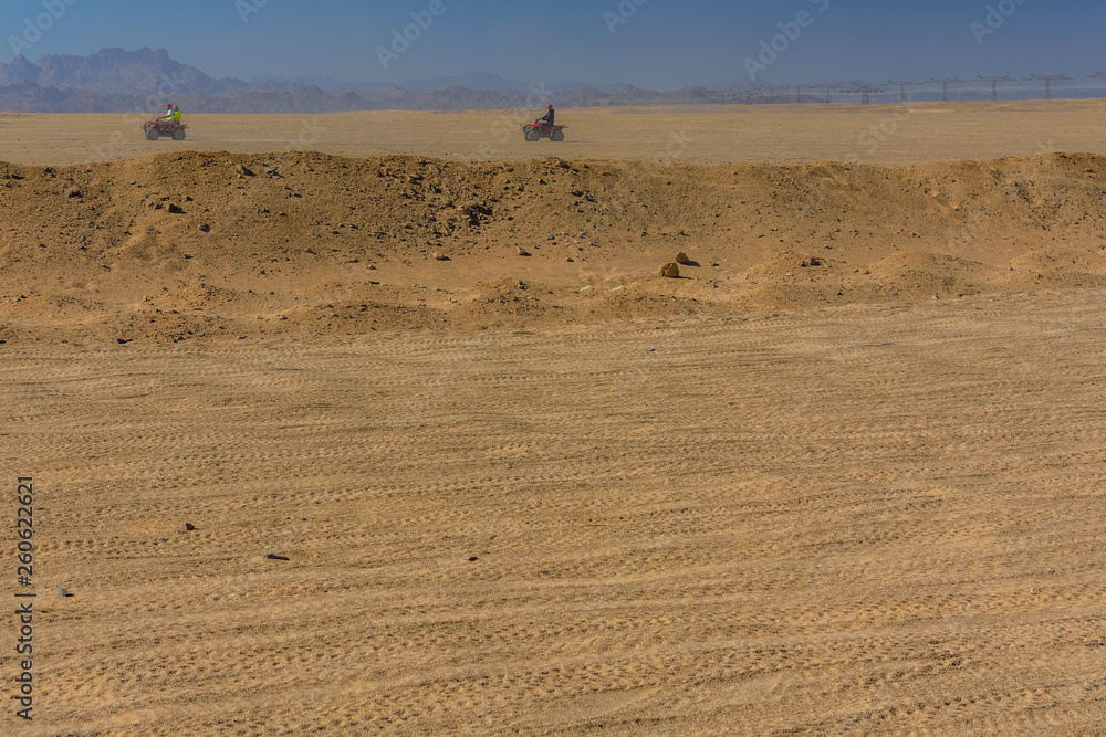 People driving quad bikes during safari trip in Arabian desert not far from the Hurghada city, Egypt