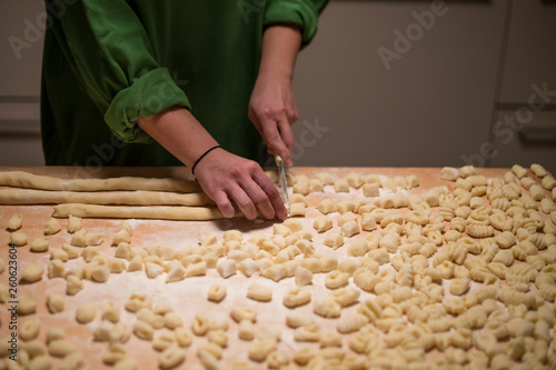 Cooks hands preparing raw pumpkin gnocchi 