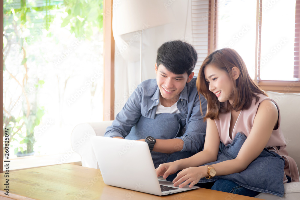 Asian young couple using laptop computer think and searching internet together, man and woman casual smiling work at home with happy and relax, communication and business concept. Asian young couple using laptop computer think and searching internet together, man and woman casual smiling work at home with happy and relax, communication and business concept.