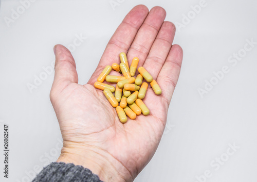 Medicine pills or capsules in elder hand