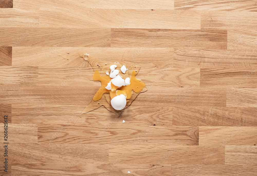 Broken egg on a wooden table Broken egg on a wooden table