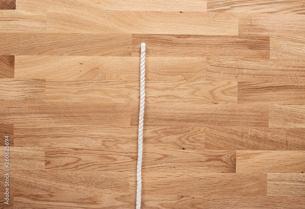 The letter I formed with white rope on a wooden table The letter I formed with white rope on a wooden table