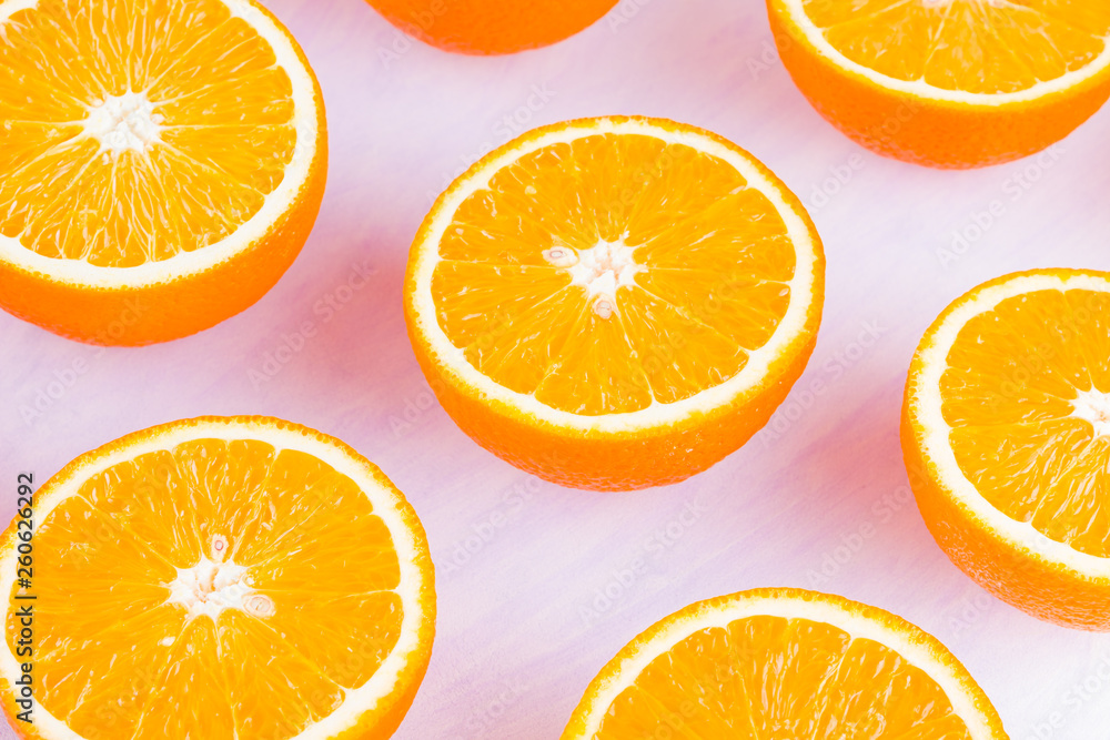 Fototapeta premium Background of oranges fruits. Many halves of fresh oranges, top view. Citrus for making juice. A lot of sliced oranges on white background. Concept