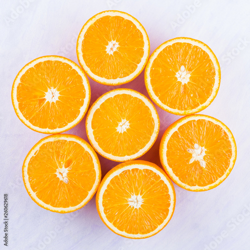 Sliced oranges fruit on white background. Citrus for making juice. Halved oranges creatively stacked on table. Background of oranges. Top view