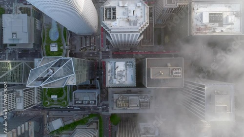 SAN FRANCISCO, CA, USA. Slow motion aerial 4K view of the unique architecture and distinguishable rooftops in San Francisco downtown. Obelisk-shaped skyscrapers covered with thick fog. photo