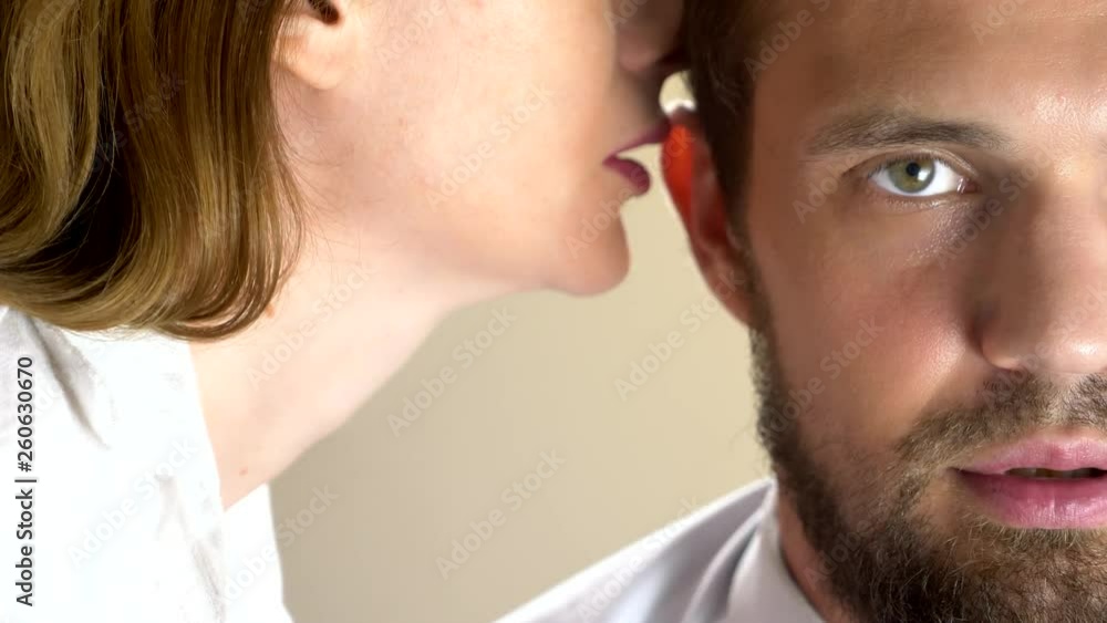 Attractive attractive seductive woman whispering pleasant words to her sleepy tired man. close-up Attractive attractive seductive woman whispering pleasant words to her sleepy tired man. close-up