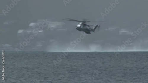 Military helicopter hovering over the ocean  photo