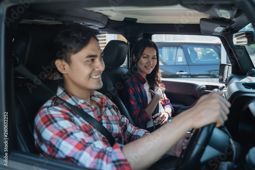 asian couple going by car together. male driver with his friend