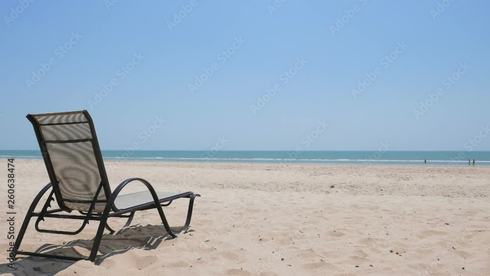 Empty Deck Chair on Untouched Sandy Beach With View on Horizon Ocean Water and Clear Blue Sky on Summer Day Empty Deck Chair on Untouched Sandy Beach With View on Horizon Ocean Water and Clear Blue Sky on Summer Day