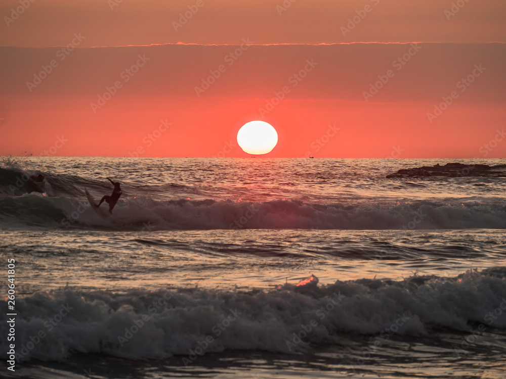Surfers enjoying a beautiful sunset surf at Montanita Ecuador