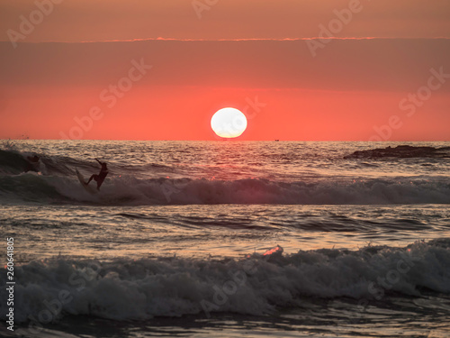Obraz na płótnie Surfers enjoying a beautiful sunset surf at Montanita Ecuador w salonie