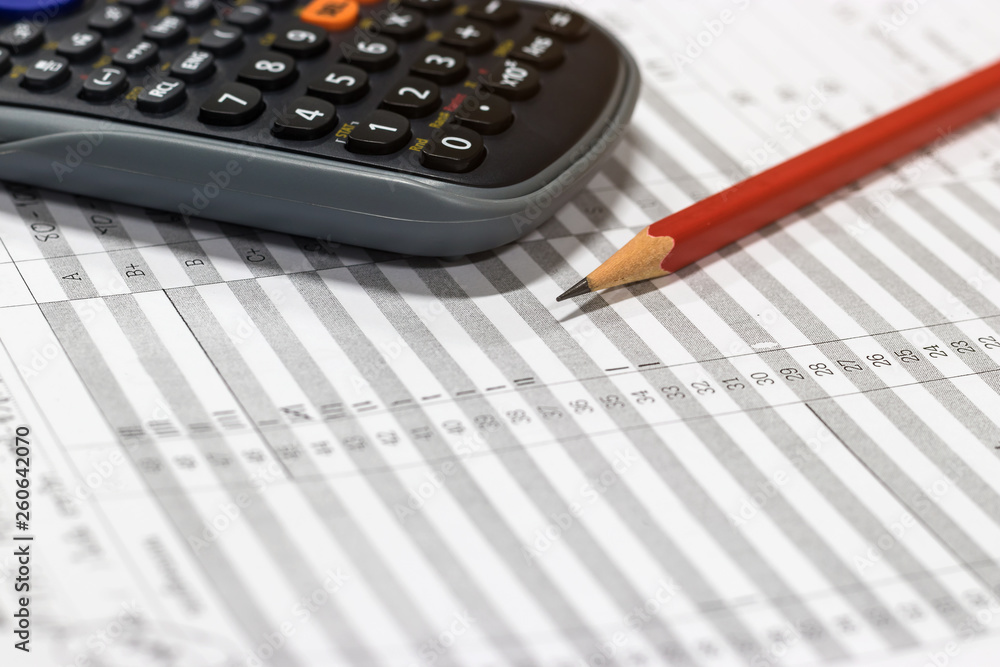 Red pencil and calculator on paper of final grade for each course at the end of semester. The number of grade points a student earned in a given period of time of school. Grading in education concept.