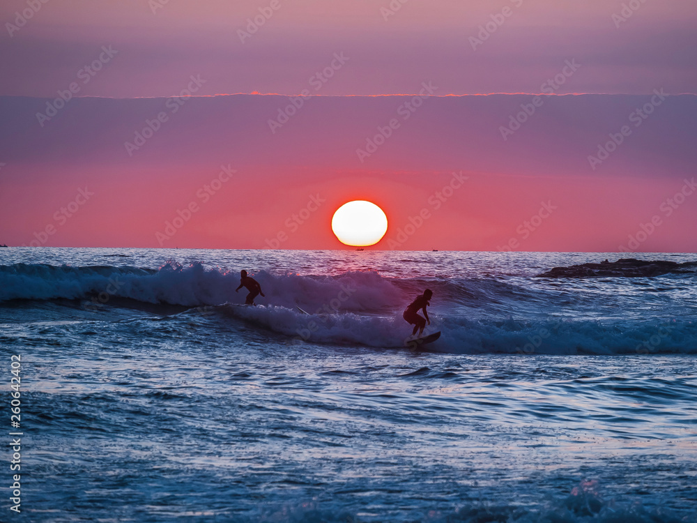 Surfers enjoying a beautiful sunset surf at Montanita Ecuador
