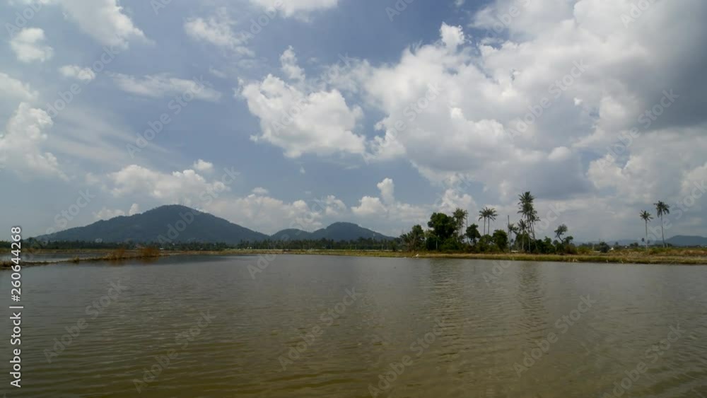 Timelapse cloud moving in hot sunny day of coconut trees and Bukit Mertajam hill reflect in water, Timelapse cloud moving in hot sunny day of coconut trees and Bukit Mertajam hill reflect in water,