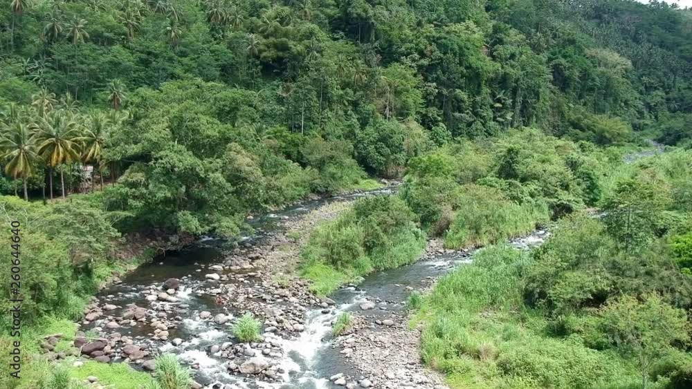 Aerial Shot Of A Small Rocky River Winding Through A Tropical Valley Aerial Shot Of A Small Rocky River Winding Through A Tropical Valley