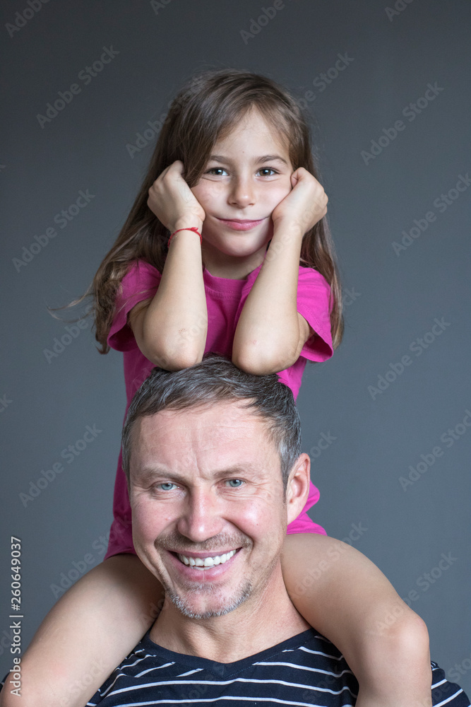 Happy smily girl sitting on dad's shoulders Happy smily girl sitting on dad's shoulders