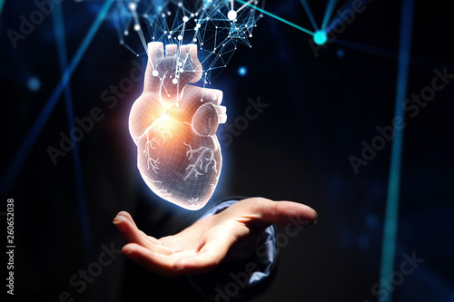 Woman s hand showing digital anatomical heart model. Mixed media.
