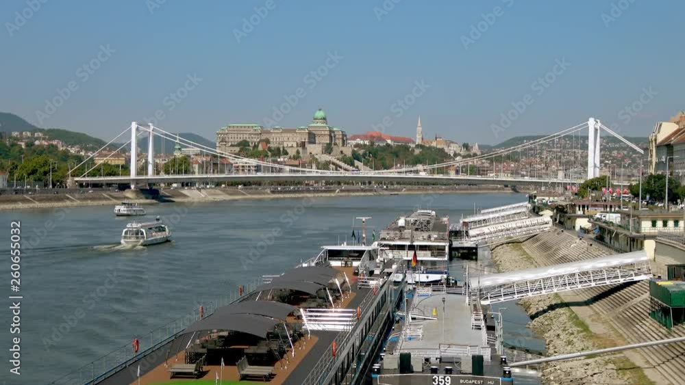 Sightseeing boats passing moored cruise ships on The Danube, Budapest, Hungary on a sunny day. Buda Castle and Fisherman's Bastion in the background. Sightseeing boats passing moored cruise ships on The Danube, Budapest, Hungary on a sunny day. Buda Castle and Fisherman's Bastion in the background.